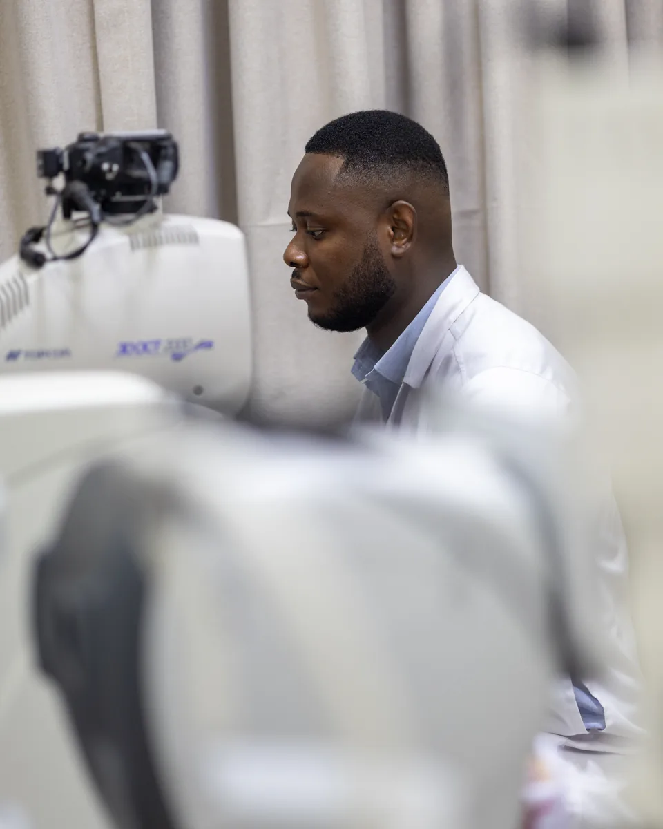 Lead Opticals optometrist working beside diagnostic equipment in Oyarifa, Accra